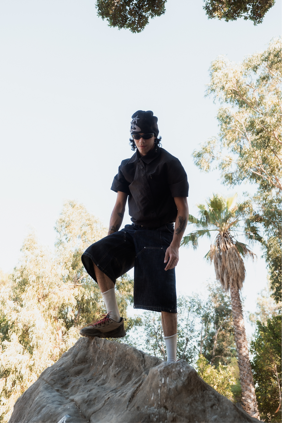 Bouldering above Los Angeles in Saturn shorts and tee