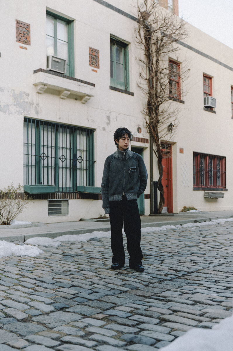 Saturn knit jacket on a cobblestone street